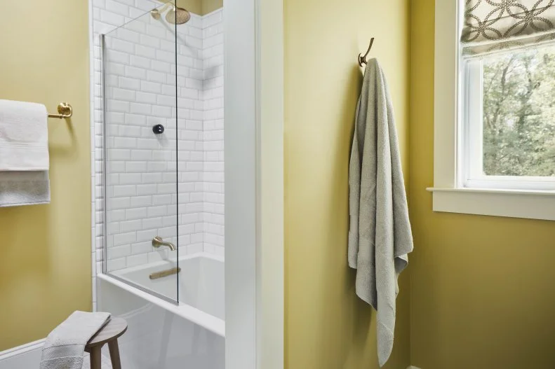 A window next to the vanity space brings natural light to the dressing area while a custom Roman Shade in a geometric print fabric adds interest while still feeling calm and relaxed. 